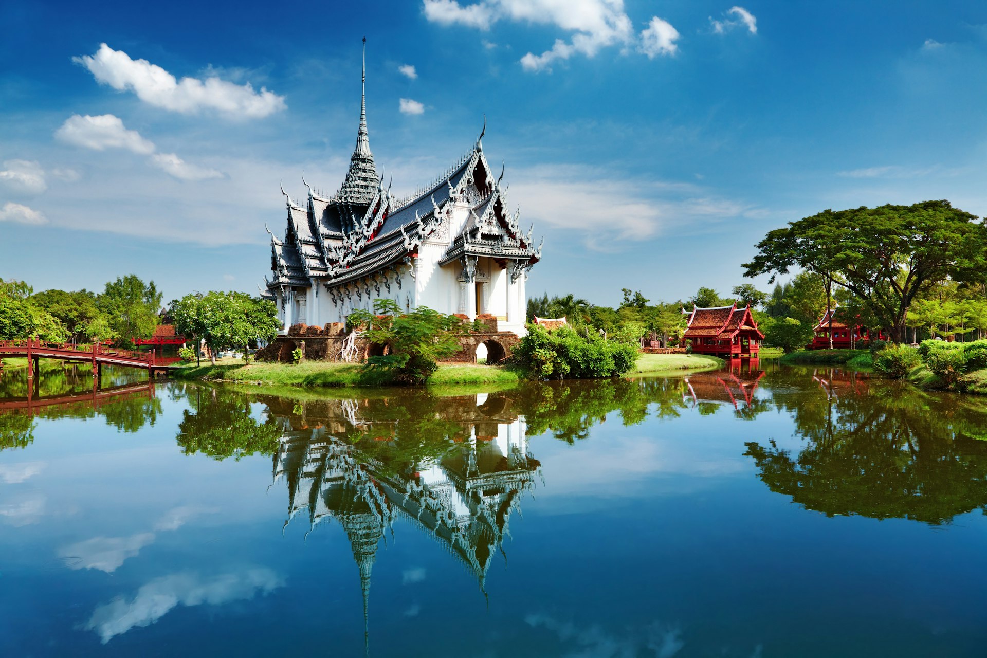The white, several-tiered Sanphet Prasat Palace sits above a peaceful lake in the Ancient City on the outskirts of Bangkok
