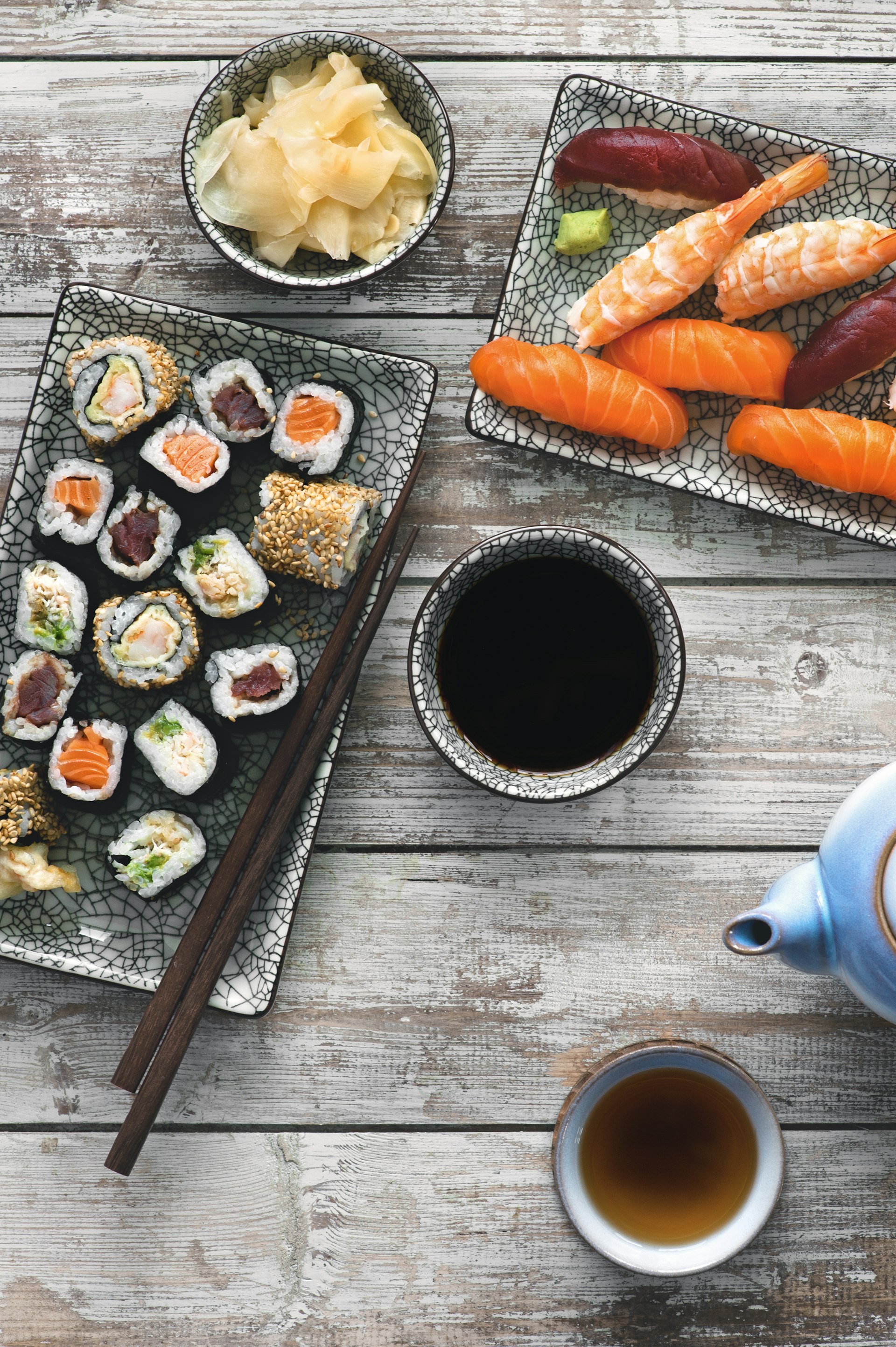 A shot of impeccably prepared Japanese dishes, including fish, sushi, cabbage, soup and tea