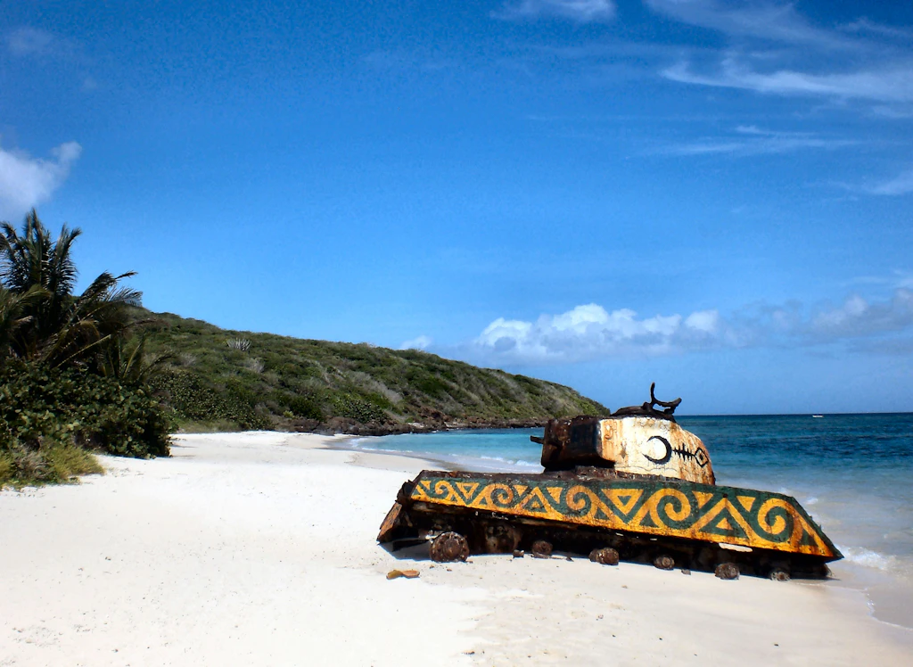 Flamenco Beach tank An abandoned tank on the white sands of Flamingo Beach, Pureto Rico which has been painted in yellow and green by a local artist