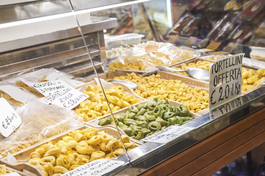 En butik i Bologna som säljer stora mängder pasta, inklusive tortellini och tortelloni.  Pastan visas bredvid priserna, skrivna på italienska.