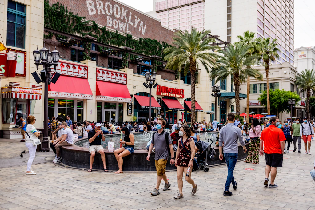 Pedestrians walk along the LINQ Promenade shopping area in Las Vegas, Nevada in front of a bowling alley called Brooklyn Bowl
