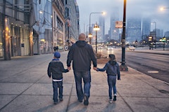 Man walking with two children through downtown Chicago 
