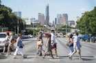 Pedestrians cross South Congress Avenue with the downtown skyline seen in the background in Austin, Texas, U.S., on Saturday, July 23, 2016. Consumer confidence was little changed in July as Americans remained positive about the job market and the business environment, according to a report from the New York-based Conference Board on Tuesday. Photographer: Matthew Busch/Bloomberg via Getty Images