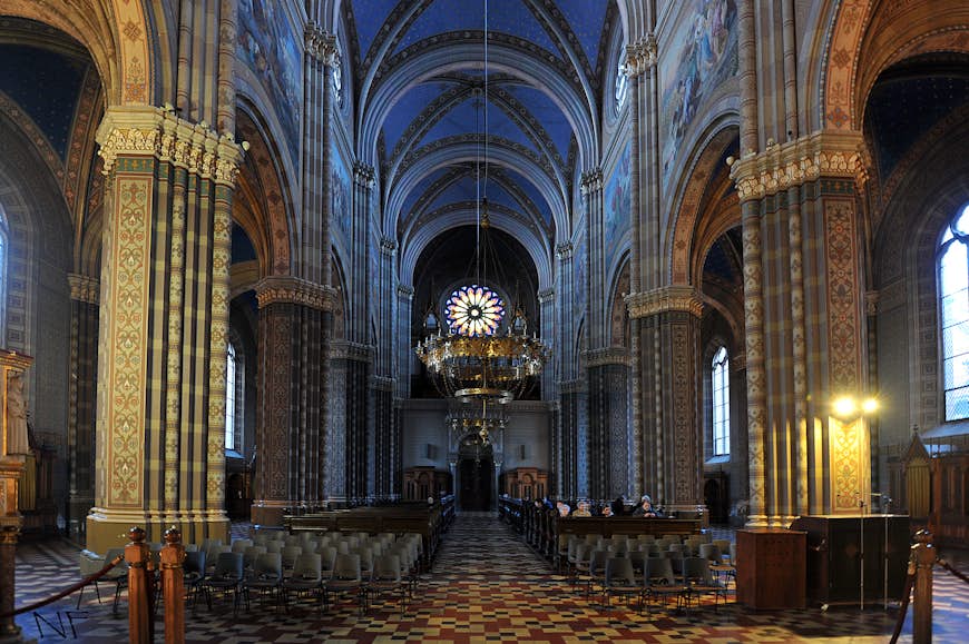 intricately restored frescoes inside a darkened cathedral