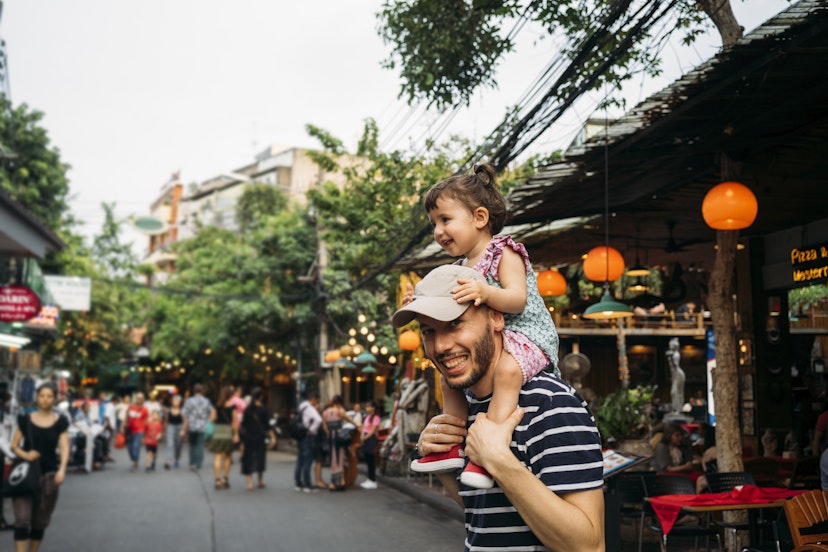 Thailand, Bangkok, portrait of smiling father and daughter on Khao San Road.