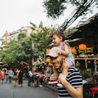 Thailand, Bangkok, portrait of smiling father and daughter on Khao San Road.