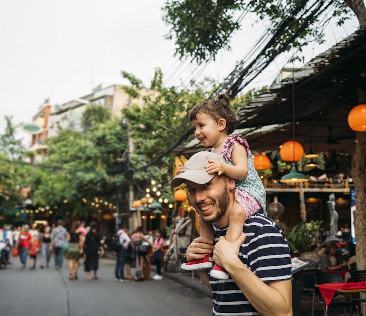 Thailand, Bangkok, portrait of smiling father and daughter on Khao San Road.