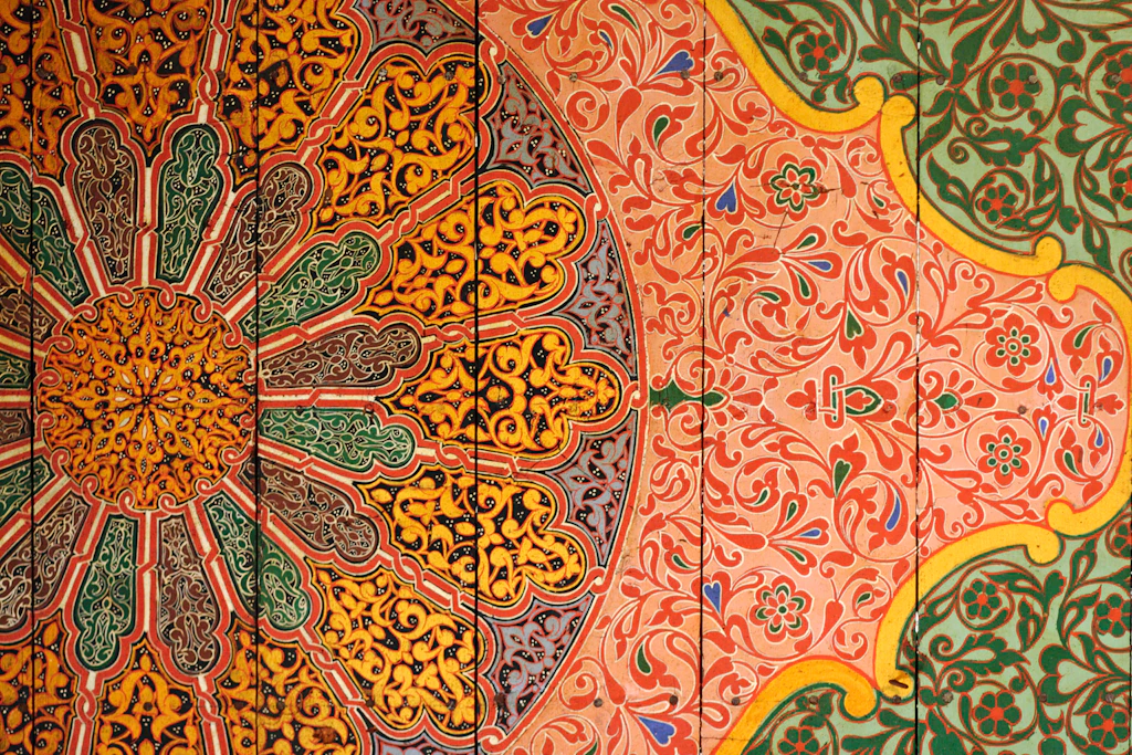 A colourful tiled mural, which appears like a large flower, on the ceiling of the Bahia palace, Marrakesh.
