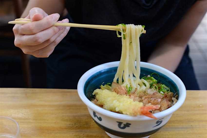 Japanese Udon Chopsticks lifting noodles above a bowl