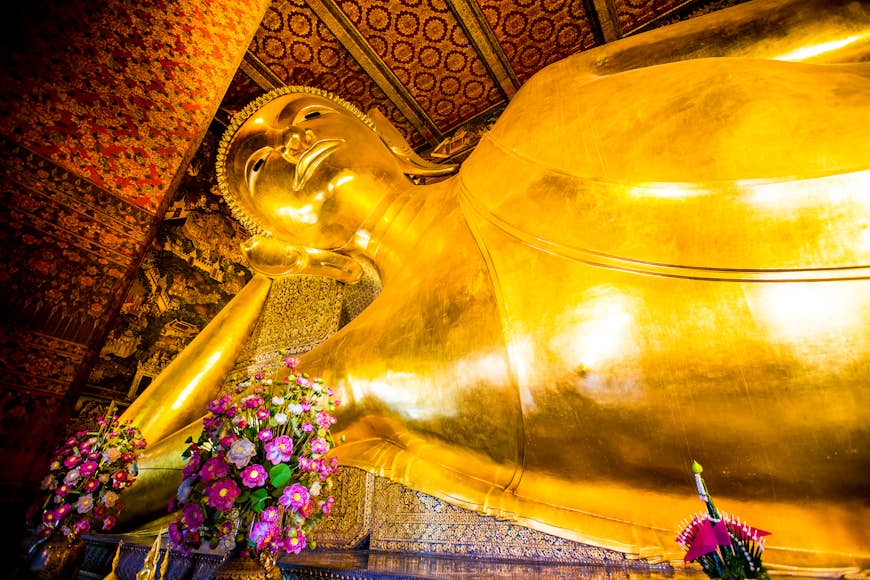 The golden, giant reclining Buddha statue lays on its side at Wat Pho temple in Bangkok, Thailand.