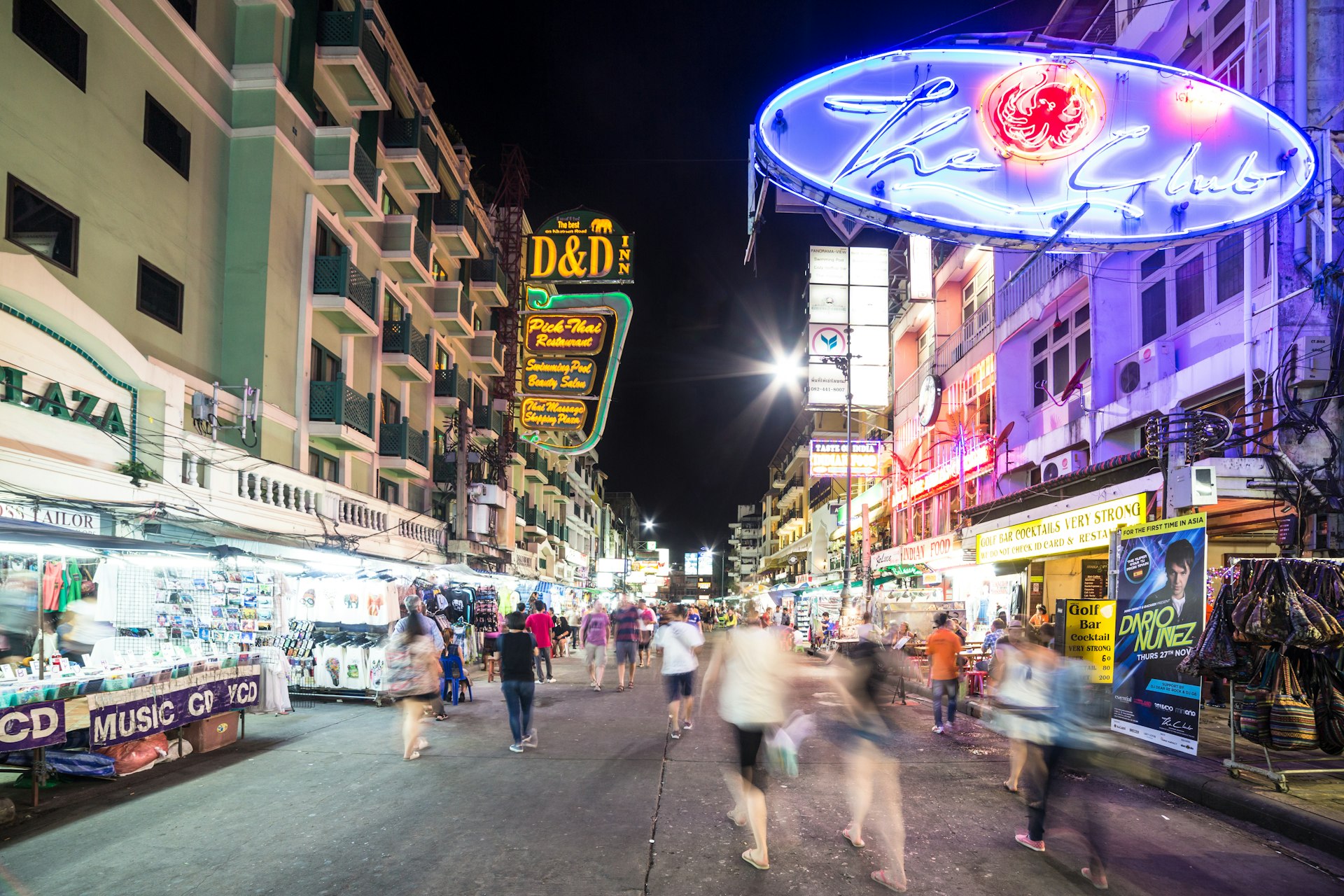 People, captured with blurred motion, walk at night along Khao San Road in Bangkok. This area is very popular with backpackers and other travelers. 