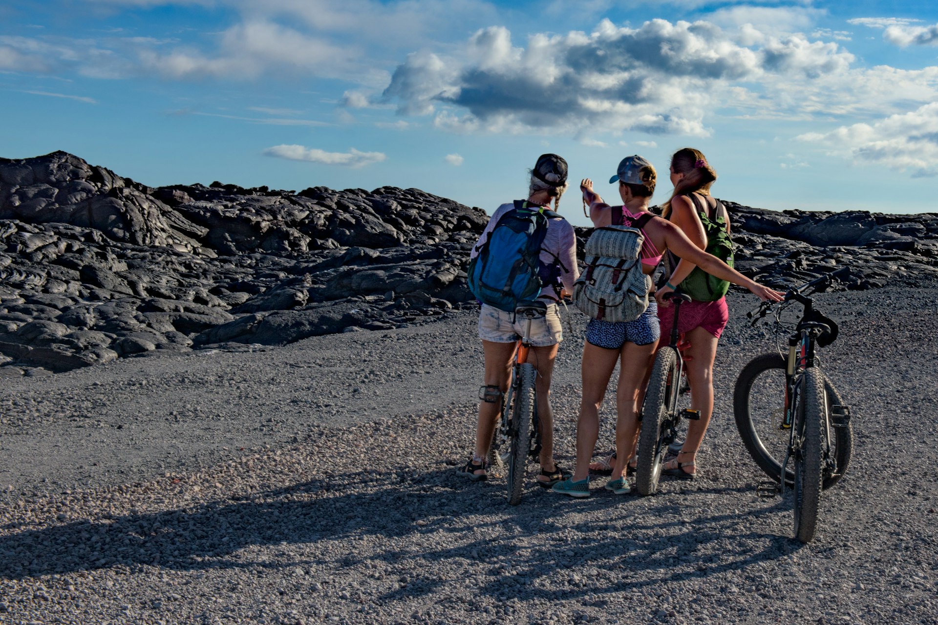 Three young women on bikes on the Chain of Craters road in Hawaii
