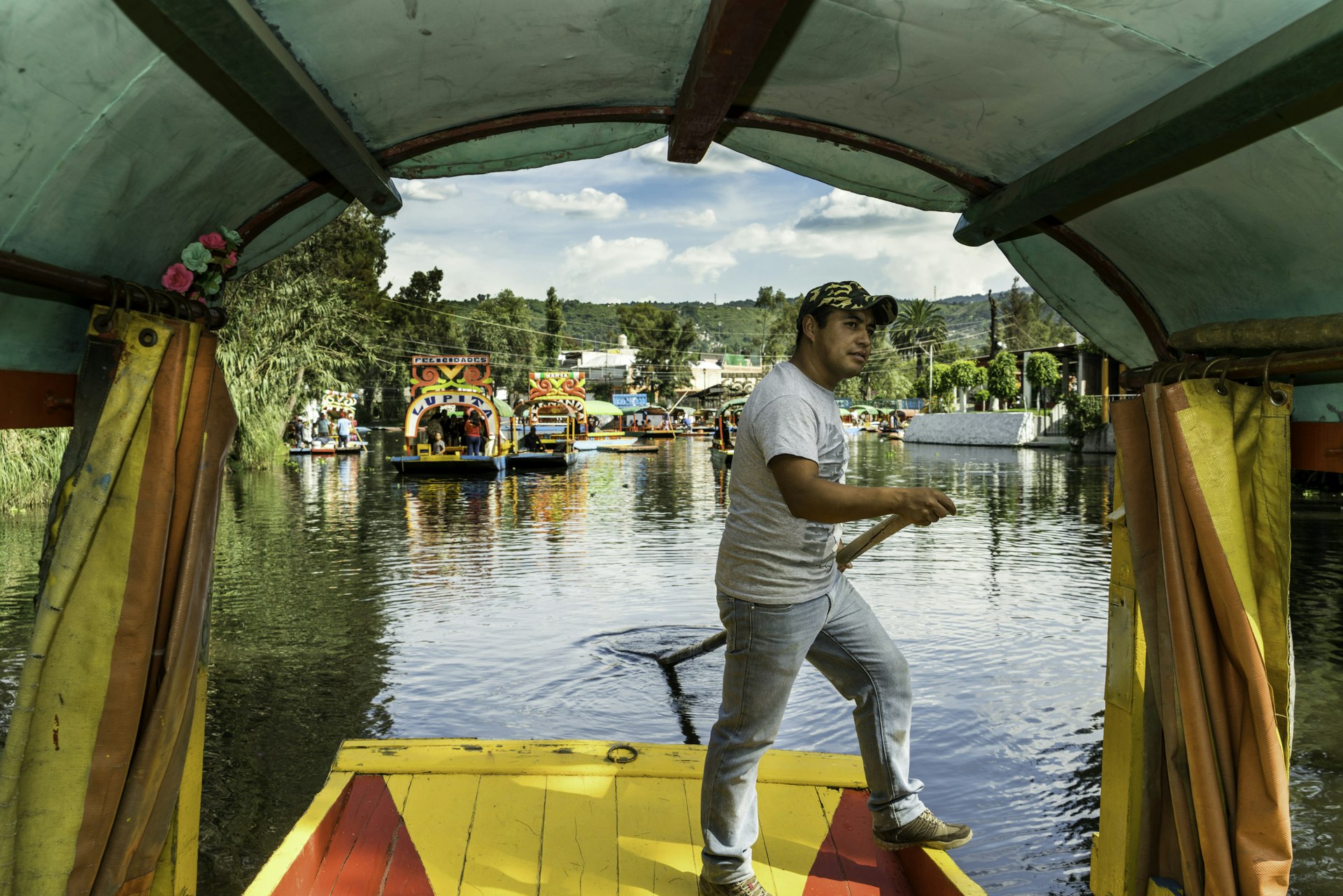 A man punts on a boat called a trajinera on the canals of Xochimilco in Mexico City