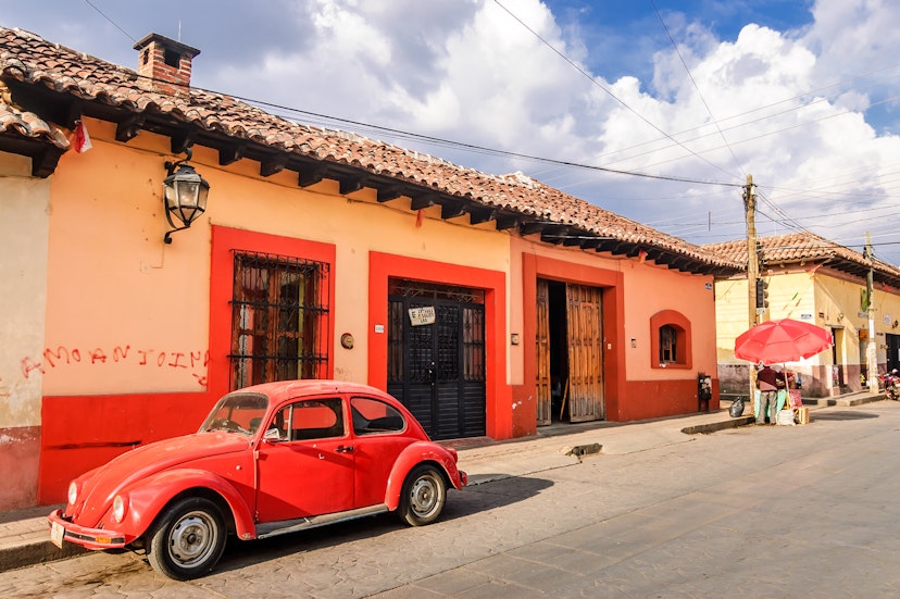 A red VW beetle in front of colourful facades in San Cristobal de las Casas.