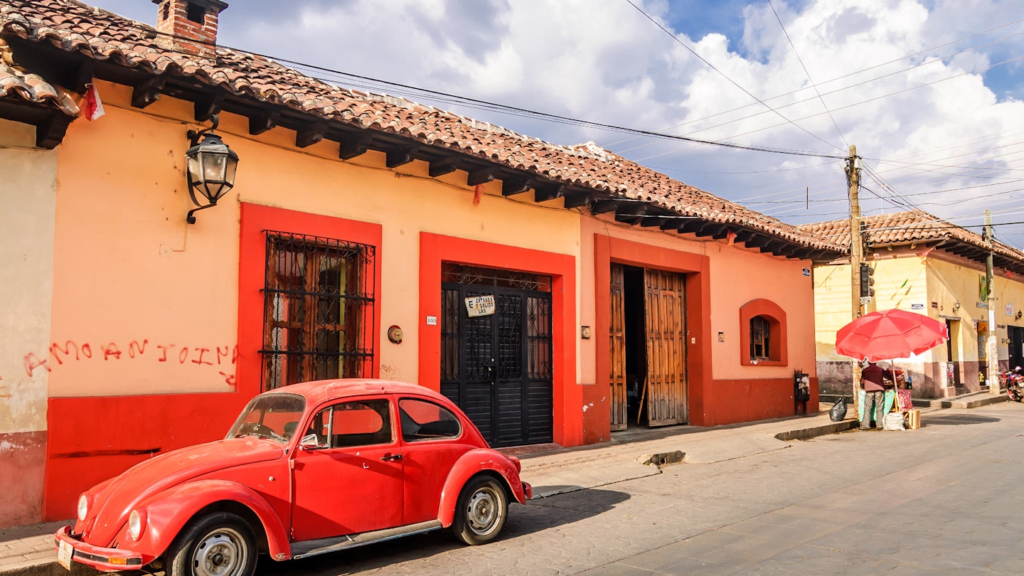 A red VW beetle in front of colourful facades in San Cristobal de las Casas.
