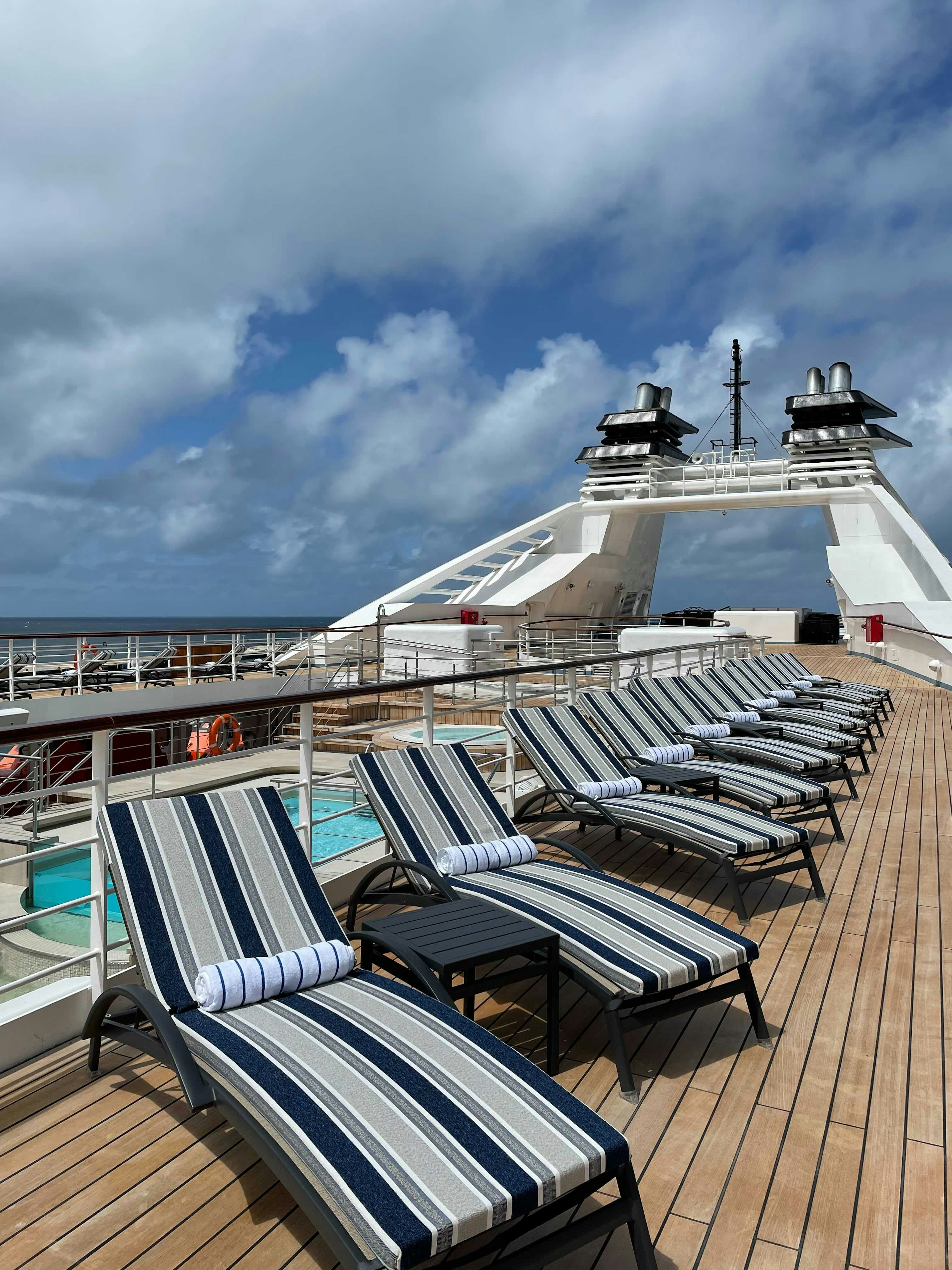 Beach beds line the edge of a cruise ship.