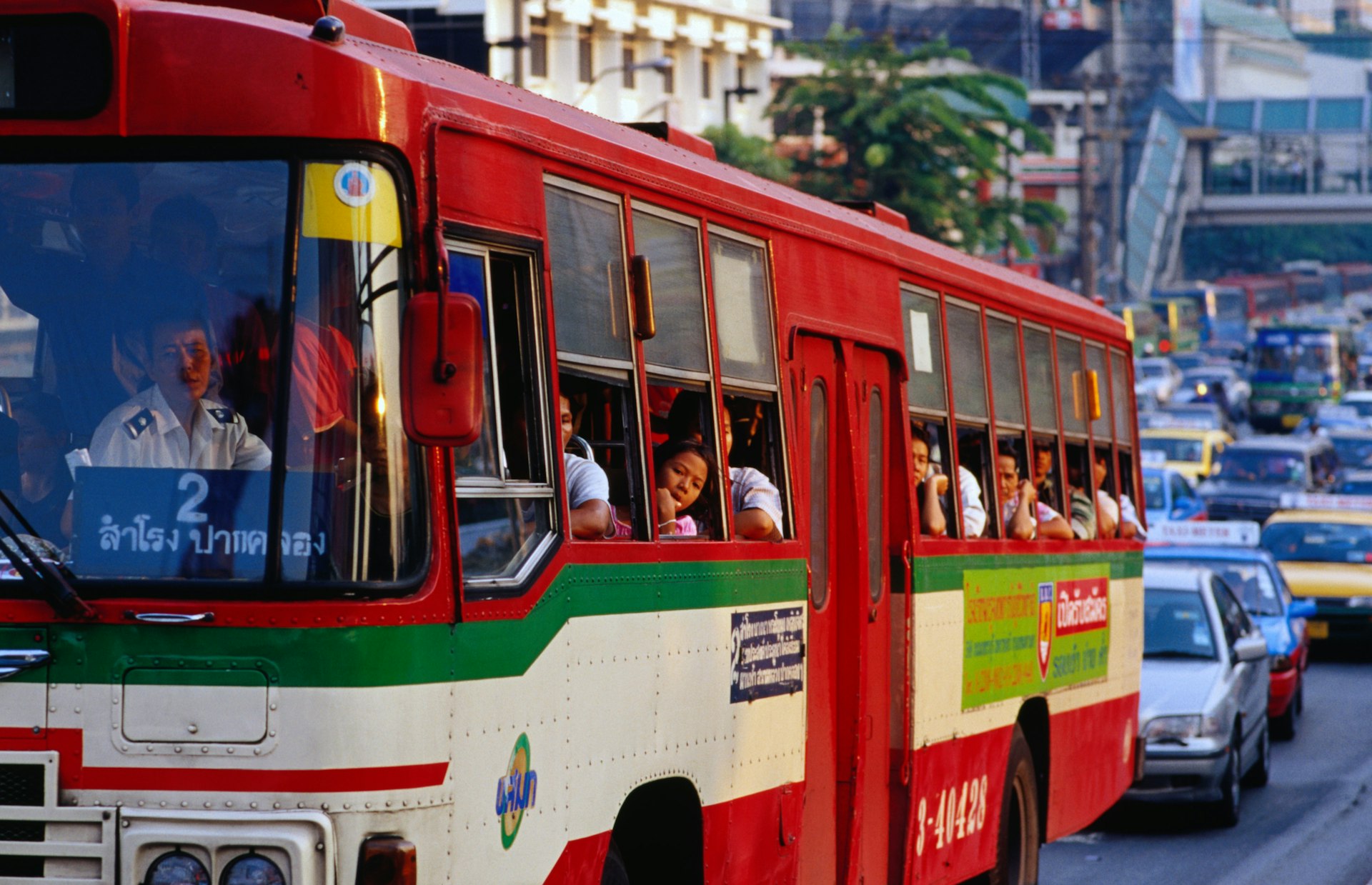 Passengers on a red bus look out of the window at the heavy traffic on Th Ratchaprarop in Bangkok.