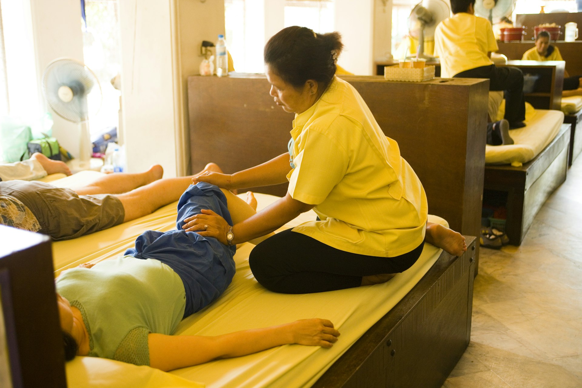 A Thai masseuse at work at Wat Po, Ko Ratanakosin in Bangkok, Thailand