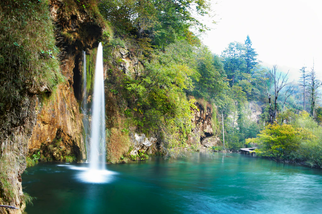 One of Plitvice’s upper lakes A waterfall cascading down into a lake