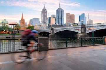 Australian people cycling  for exercise near Yarra River with view of the Melbourne City Financial District with skyscrapers in morning at Melbourne, Victoria, Australia.