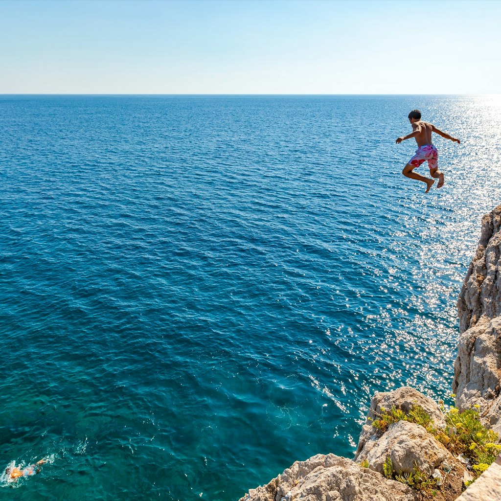 A boy is jumping from the cliff. Holidays in Montenegro; Shutterstock ID 634103288; your: Ben N Buckner; gl: 65050; netsuite: Client Services; full: Montenegro