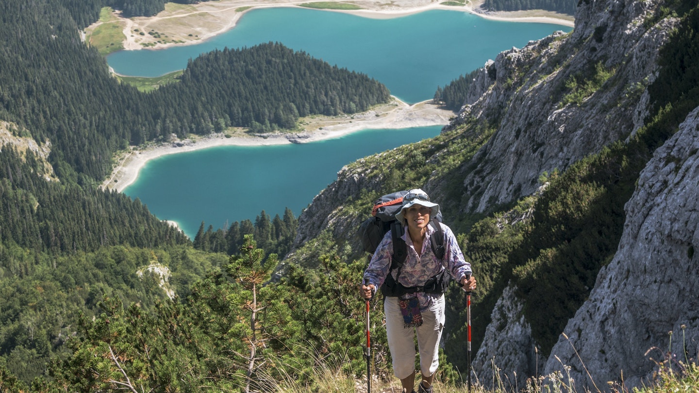 Scene in Durmitor mountains (Montenegro). Woman with backpack against Black Lake background.; Shutterstock ID 791462698; your: Ben N Buckner; gl: 65050; netsuite: Client Services; full: Montenegro