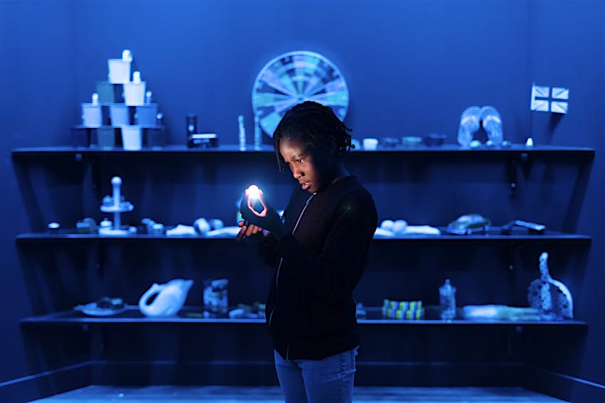 Wonderlab at the Science Museum A child holds a small light in a room lit up in blue