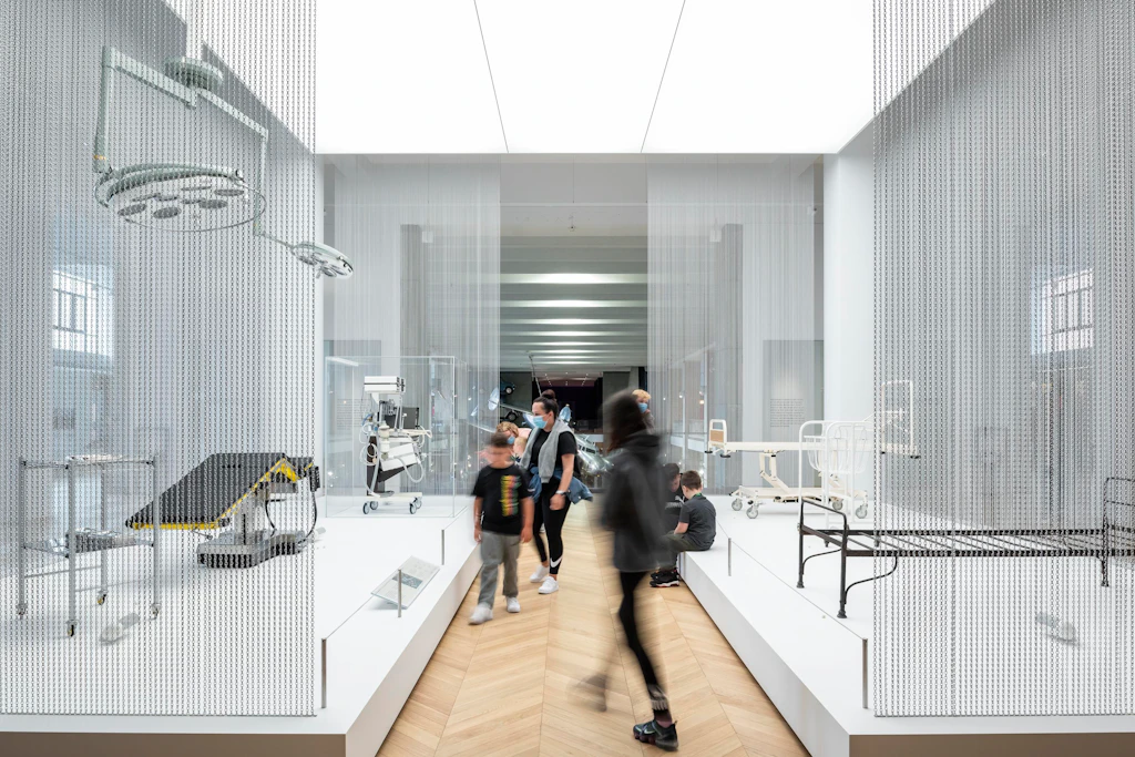 Visitors in the Medicine Galleries at the Science Museum Visitors walk around a white room with medical instruments and equipment on display