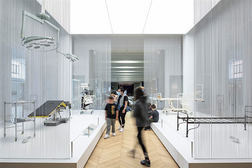 Visitors in the Medicine Galleries at the Science Museum Visitors walk around a white room with medical instruments and equipment on display