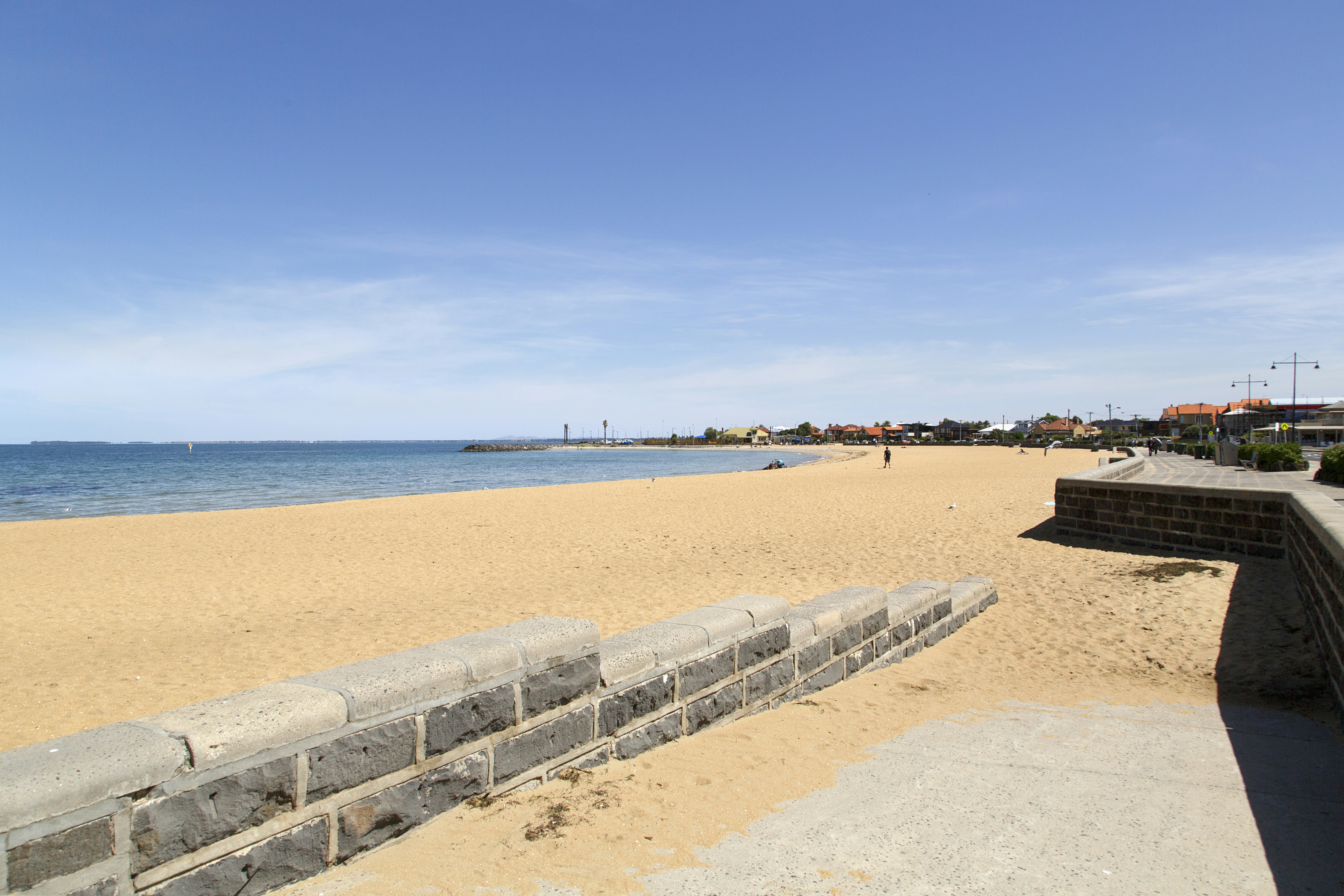 Williamstown Beach in Melbourne. A vast segment of white sand curving round the headland.
