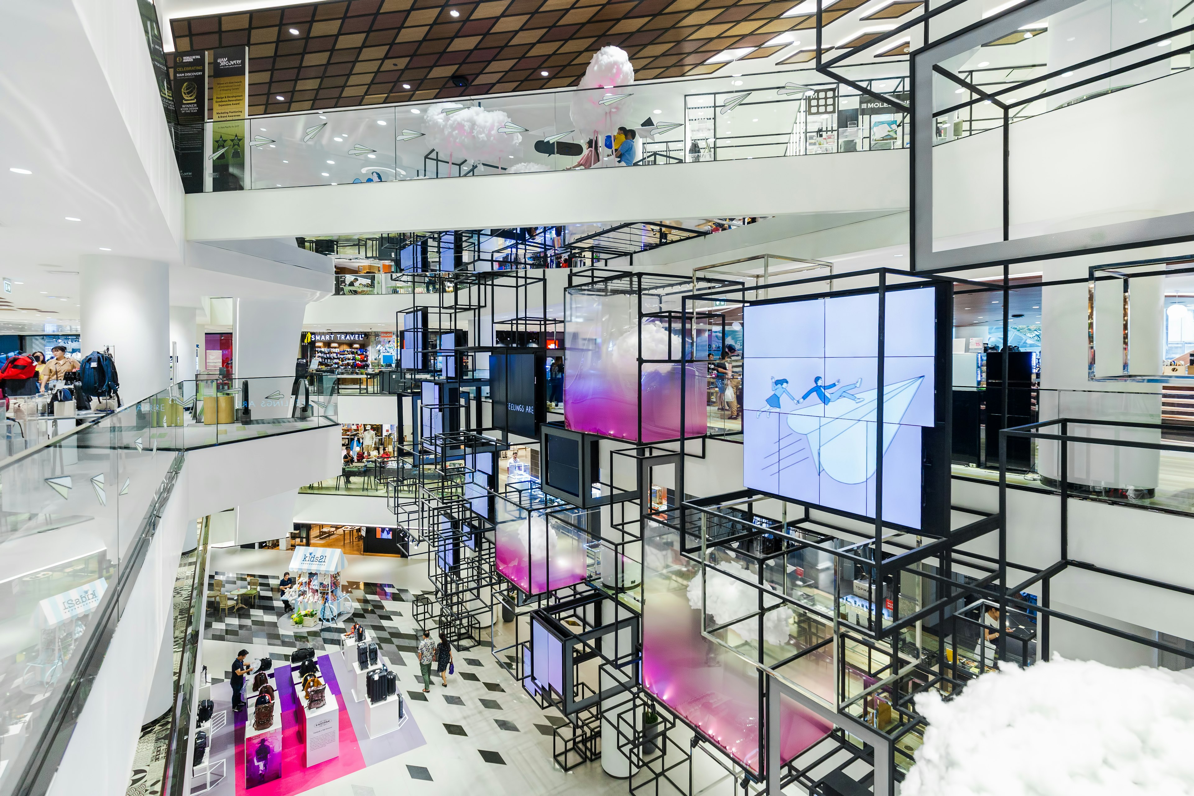 The white gleaming modern interior design of a shopping center over two floors