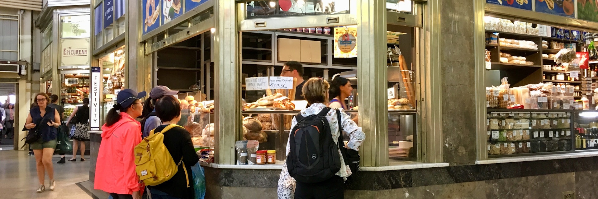 Melbourne, Australia: April 12, 2018: Customers buy pastries and other food goods from a stall in Queen Victoria Market.
