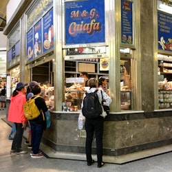 Melbourne, Australia: April 12, 2018: Customers buy pastries and other food goods from a stall in Queen Victoria Market.