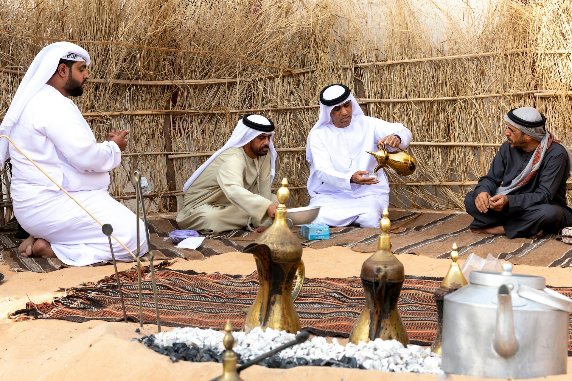 Arabic men drinking coffee inside a traditional Bedouin tent