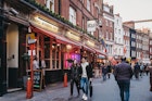 April 14, 2019: People walking past Ku Bar, one of the largest gay bars in London, located just off Leicester Square.
