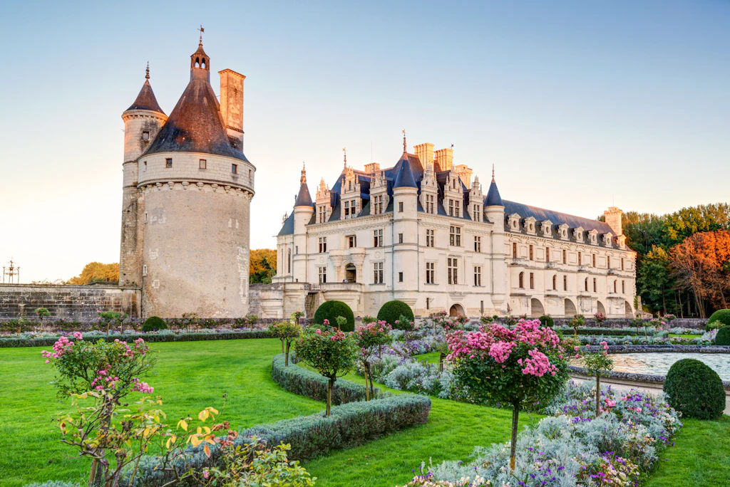 A shot through formal gardens towards a chateau with a rounded turret