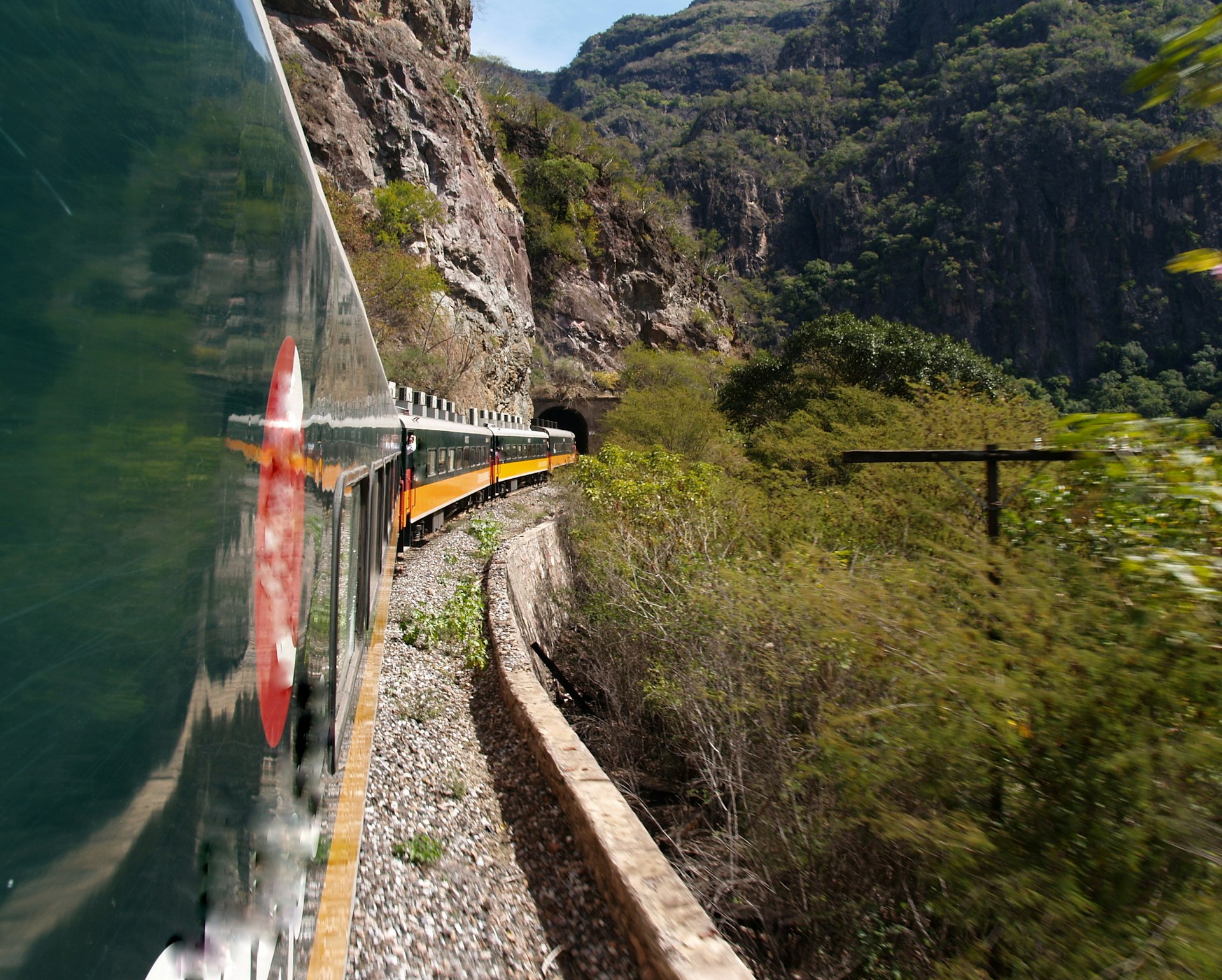 View of the side of train carriages winding their way along the Copper Canyon Railway