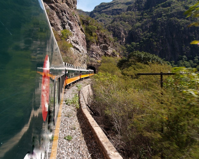 View of the side of train carriages winding their way along the Copper Canyon Railway