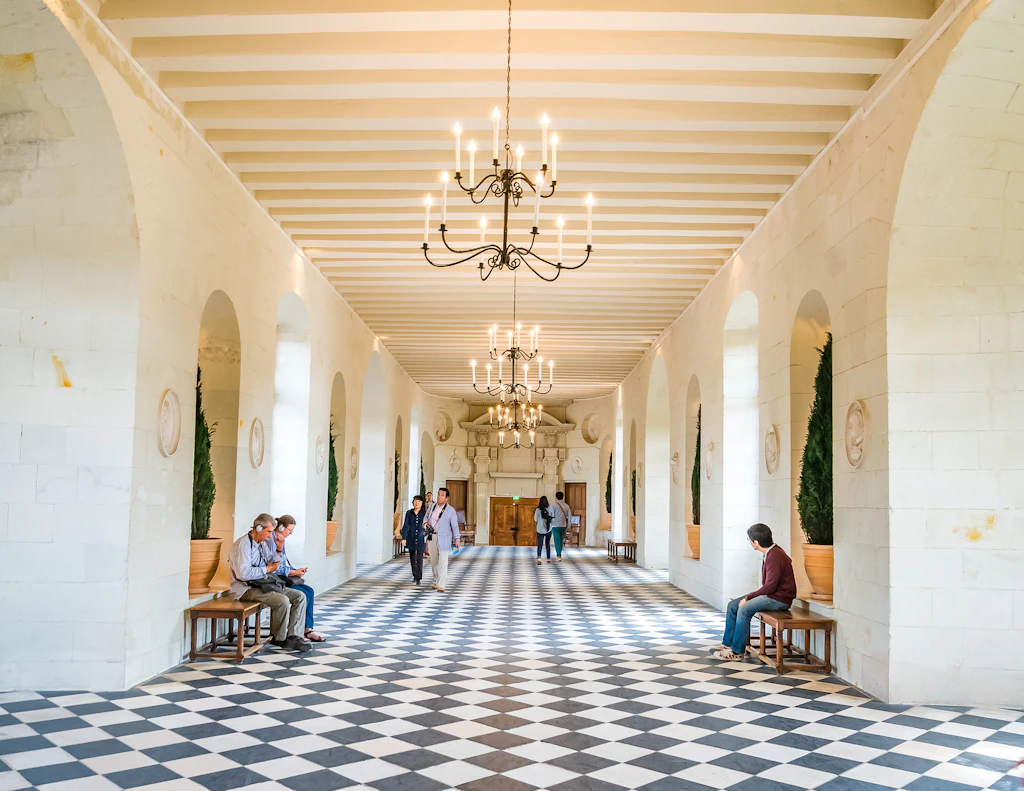 A long wide passageway with a black-and-white tiled floor. 