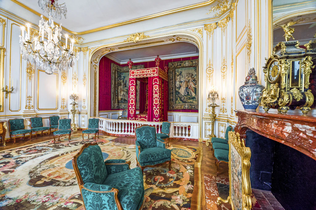 A heavily decorated very grand bedroom with ornate furniture