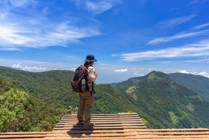 A solo hiker stands looking out over a viewpoint in Sri Lanka