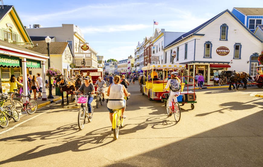 Cyclists ride on Market Street on Mackinac Island on a sunny day in Michigan