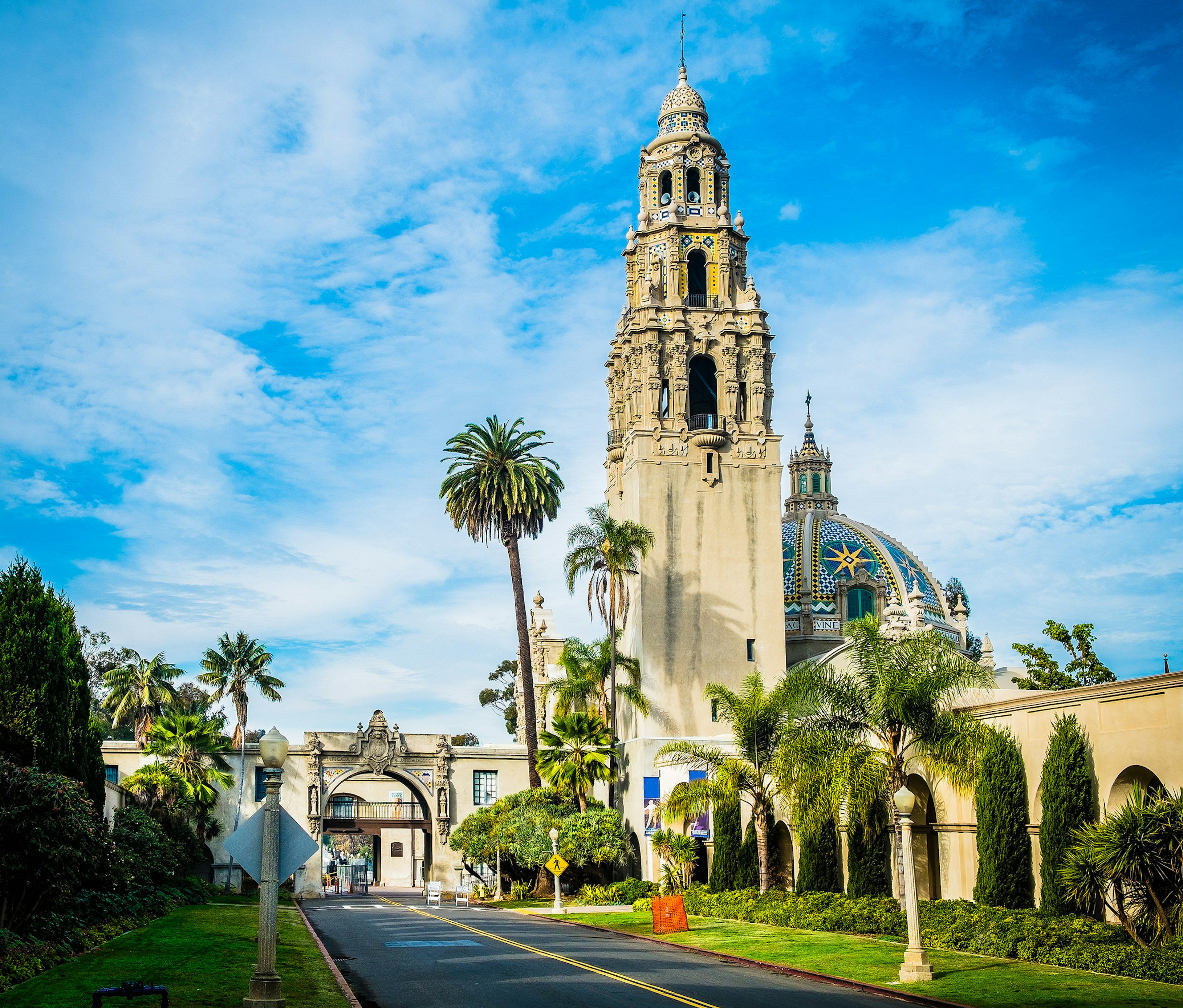 A building with a tall bell tower in landscaped parkland