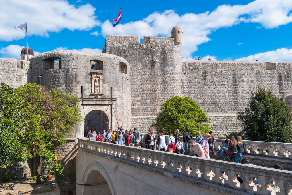 Pile Gate, Dubrovnik A line of people entering a walled city through a fortified stone gate tower