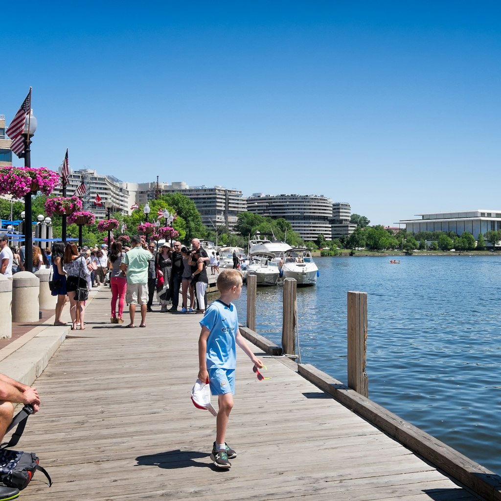 May 24, 2015: Georgetown waterfront dock crowded with people. The Kennedy Center and Watergate complex in the background.