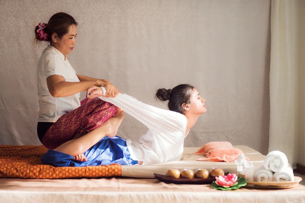 A woman receiving a traditional Thai massage at the Wat Pho Thai Traditional Massage School in Bangkok, Thailand