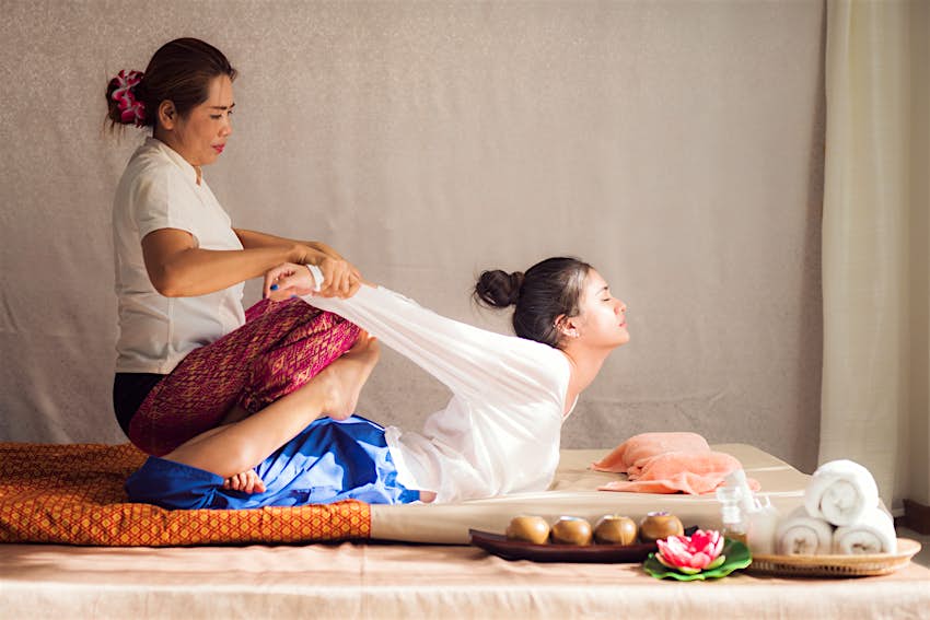Wat Pho Thai Traditional Massage School A woman receiving a traditional Thai massage at the Wat Pho Thai Traditional Massage School in Bangkok, Thailand