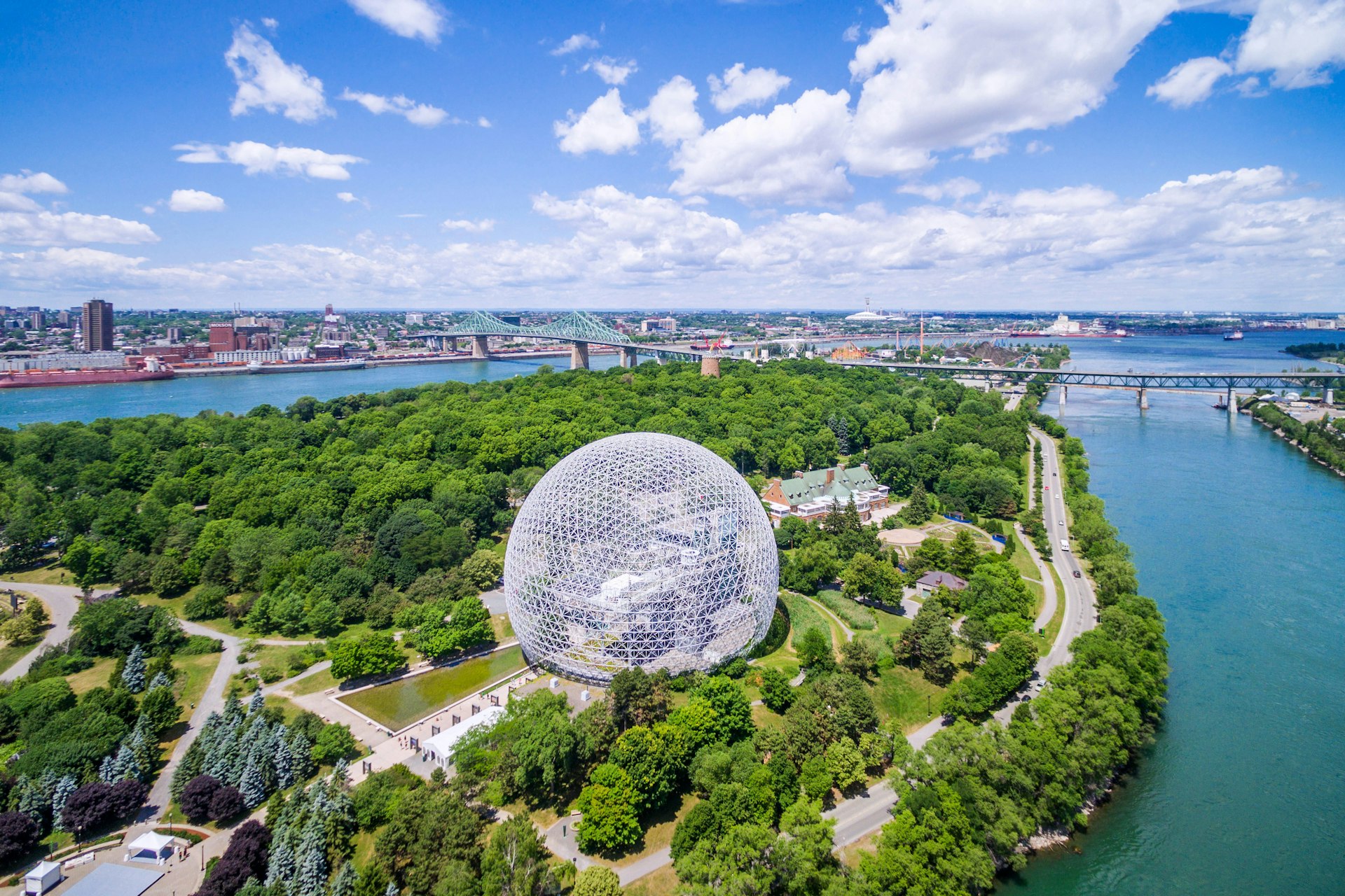 Aerial of the Montreal cityscape, including the Biosphere geodesic dome and Jacques Cartier bridge.