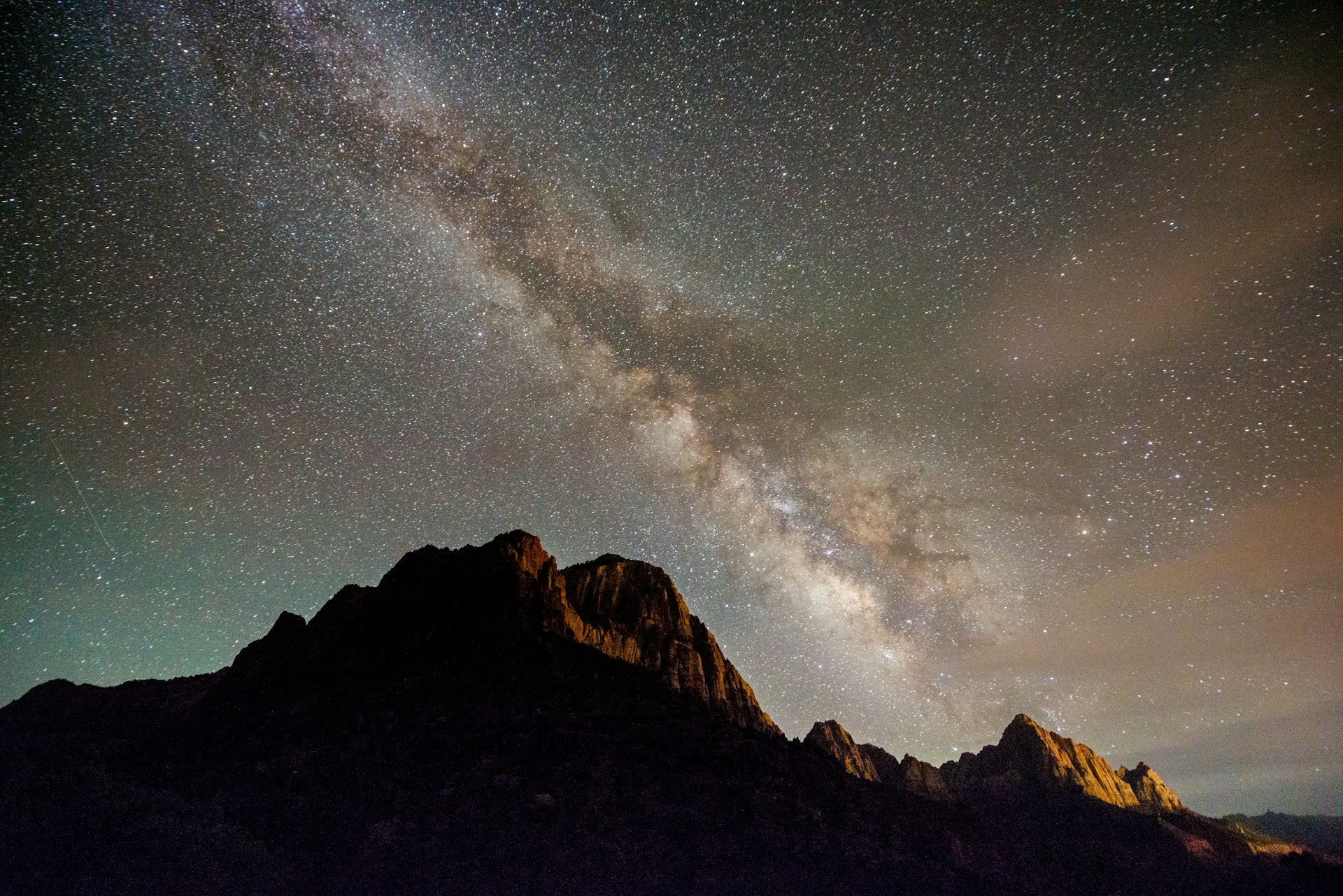 Milky Way night sky shines over the Watchman in Zion National Park. 