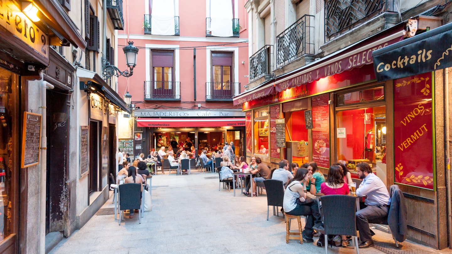 People seated at outdoor restaurants and bars in Huertas.